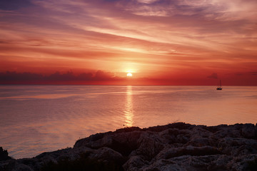 Beautiful colorful sunrise at the sea with dramatic clouds and sun shining