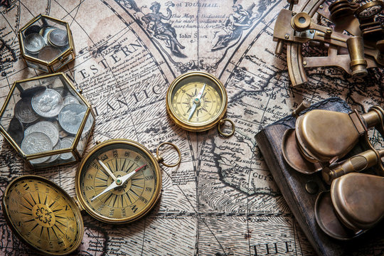 Compass, sextant and old coins on vintage map. Retro style.