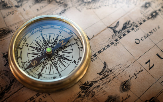 Old compass on vintage map. Retro style.