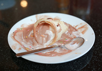 melting ice cream cone on dirty dish