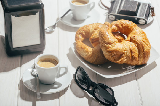 Espresso coffee cup and croissant on outdoor table