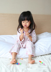 Naklejka premium Little child girl play and learn magic color on the bed at the morning.