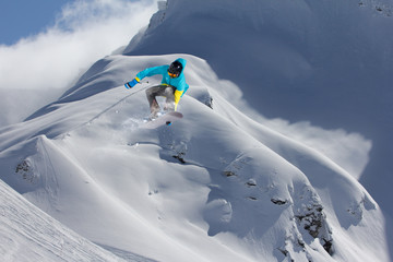 Jumping snowboarder in winter mountain. Extreme sport.