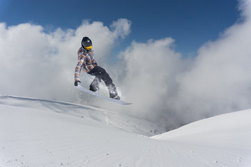 Jumping snowboarder in winter mountain. Extreme sport.