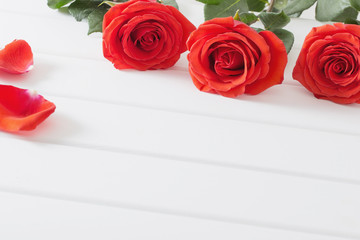 red roses on white wooden planks background
