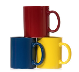 Three colorful mugs for coffee or tea, isolated on white background