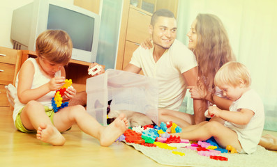 Obraz na płótnie Canvas Family of four at home with toys