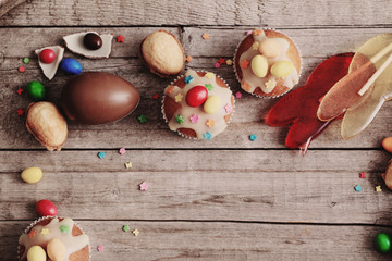 Chocolate Easter Eggs and Cake Over Wooden Background