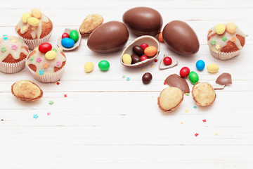 Chocolate Easter Eggs and Cupcake Over Wooden Background