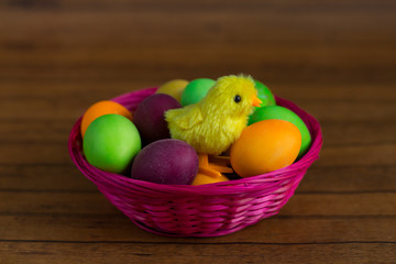 Easter eggs and little chicken in basket