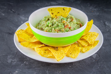 nachos with guacamole on a gray background