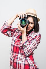 Woman traveler taking picture with camera on grey background