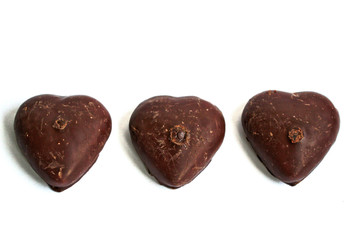 Chocolate covered gingerbread hearts on a white background