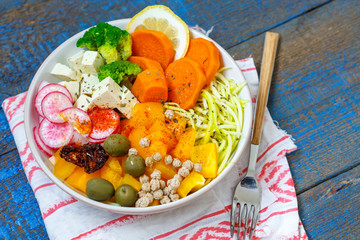 Vegan Buddha bowl - zucchini pasta, sweet potatoes, tofu with vegetables. Love for a healthy vegan food concept