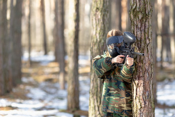 Fototapeta premium girl playing paintball in overalls with a gun.