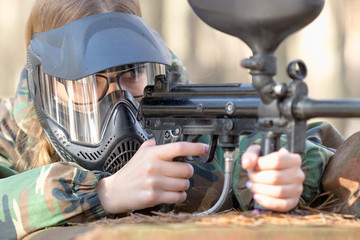 Fototapeta premium girl playing paintball in overalls with a gun.