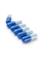 Blue capsules and pills background