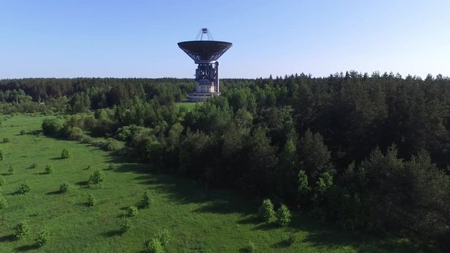 A huge radio telescope in the forest. The steerable parabolic reflector 64 meters diameter. Observatory for spectral radio astronomy, physics of pulsars and pulsar astrometry, studies of galactic and 