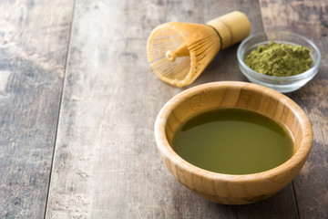 Obraz na płótnie Canvas Matcha green tea in a bowl and bamboo whisk, on wooden background 