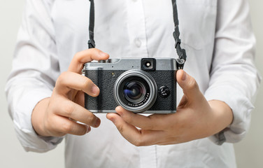 Female hand holding modern camera (mirrorless camera). camera in hand