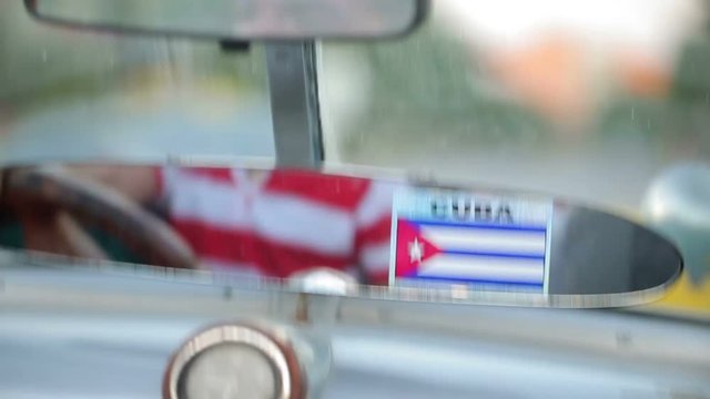 Rear mirror in old car with cuba flag