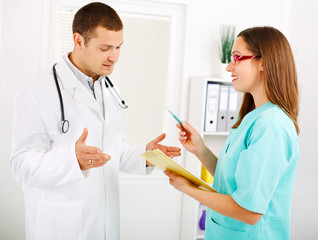 Doctor and nurse talking at the office.