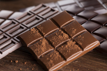 Dark homemade chocolate bars and cocoa pod on wooden
