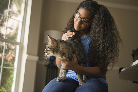 A girl with a cat on her lap. 
