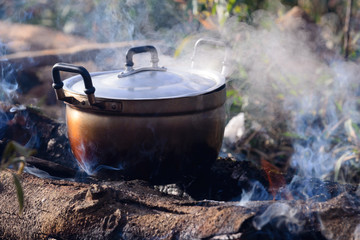 Cooking with cauldron on campfire.