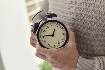 man winding or adjusting the time of a clock