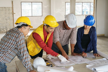 business people group on meeting and presentation with construction engineer architect looking building model and blueprint plans