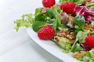 Vegan spring salad with raspberries and nuts
