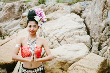 Portrait of Thai girl in Thailand traditional dress with flowers on her hair style on sea shore. Welcome to Thailand