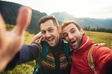 Smiling hikers taking a selfie while trekking in the wilderness
