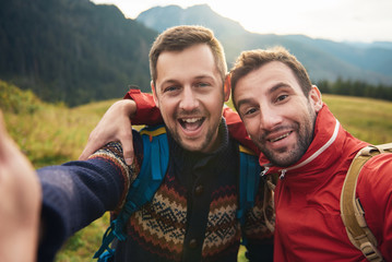 Smiling hikers taking a selfie together in the wilderness