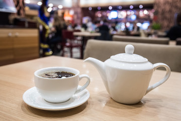 Teapot and cup of tea in cafe