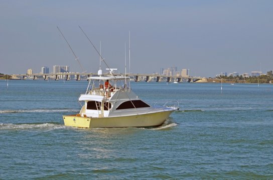 Sport Fishing Boat on the Florida Intra-coastal Waterway with the Julia Tuttle causeway bridge and Miami and North Miami beach skylines in the distant background.