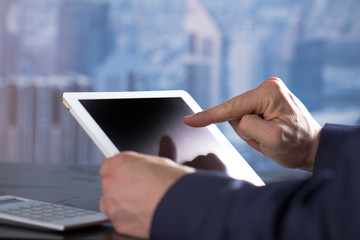 Man witch tablet in office Dubai backbround