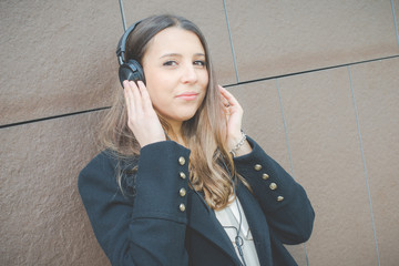 young authentic business woman relaxes listening to music in the city
