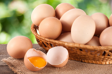 eggs in a wicker basket on a wooden board with blurred garden background