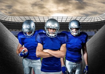 American football players standing against stadium in background