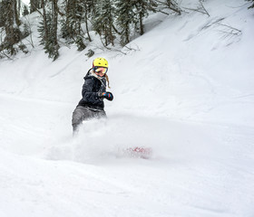 Woman snowboarder in motion in mountains