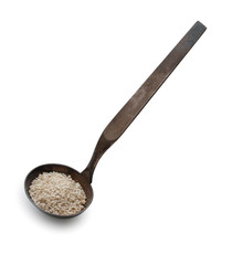 Vintage silverware, Very old dark rusted ladle, scoop with seeds of sesame, isolated on a white, close up.