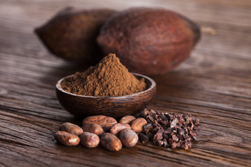 Cocoa beans in the dry cocoa pod fruit on wooden background