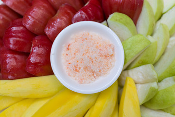organic raw fruit in red, green and yellow with spicy seasoning salt