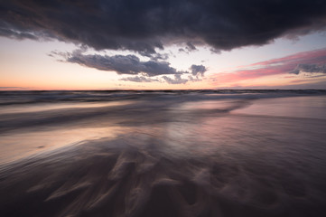 Naklejka na ściany i meble Ocean sunset scene with waves photographed with long exposure