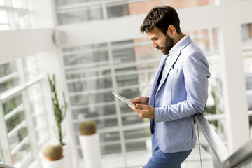 Handsome businessman with tablet in office