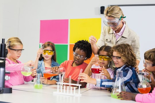 Teacher assisting kids in laboratory