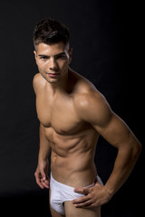 Fototapeta na wymiar Handsome muscular young man posing in the studio