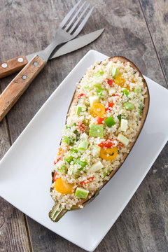 Stuffed eggplant with quinoa and vegetables on wooden background
